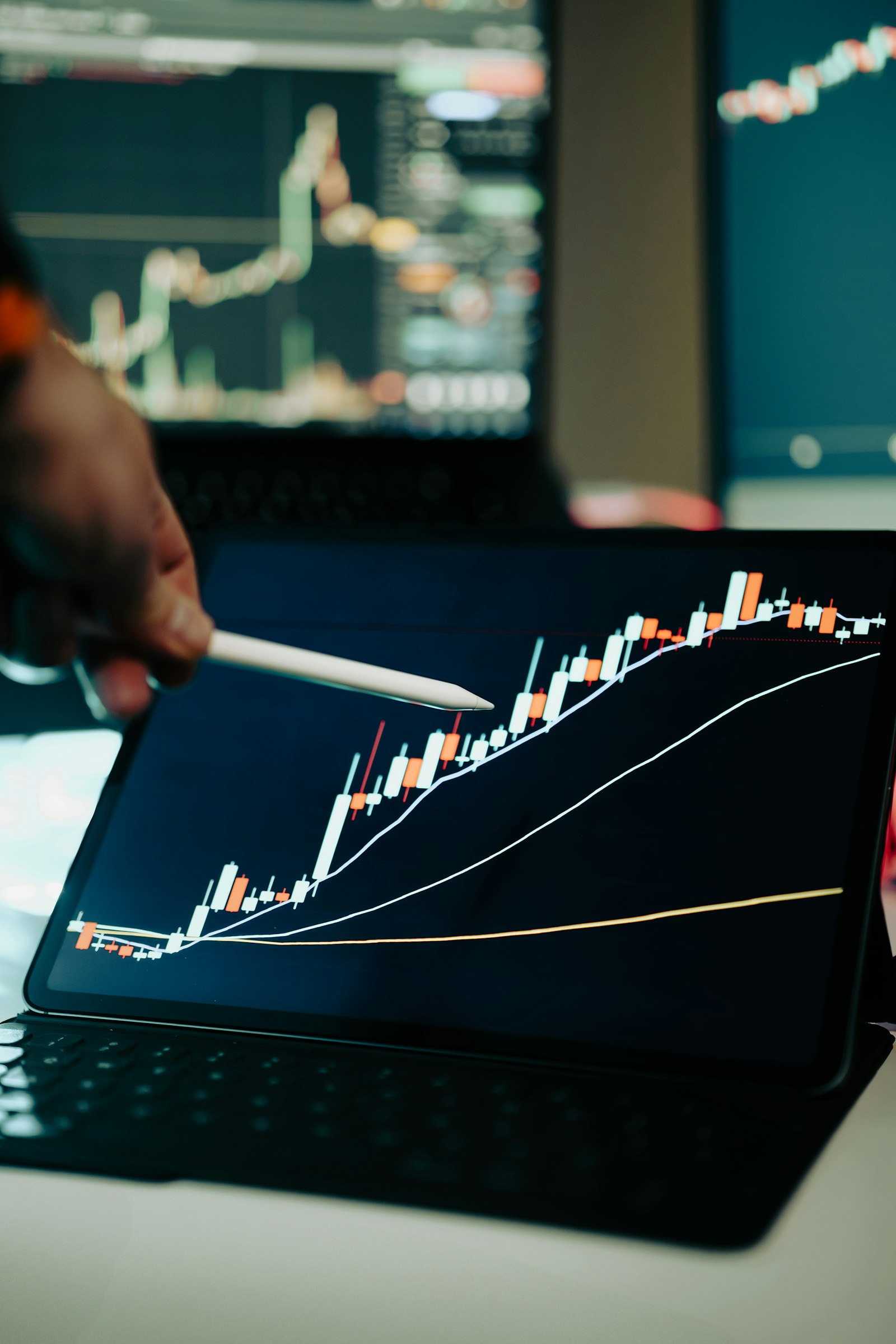 A hand pointing at a rising performance chart on a screen, representing the measurable results of a 12-month business improvement engagement