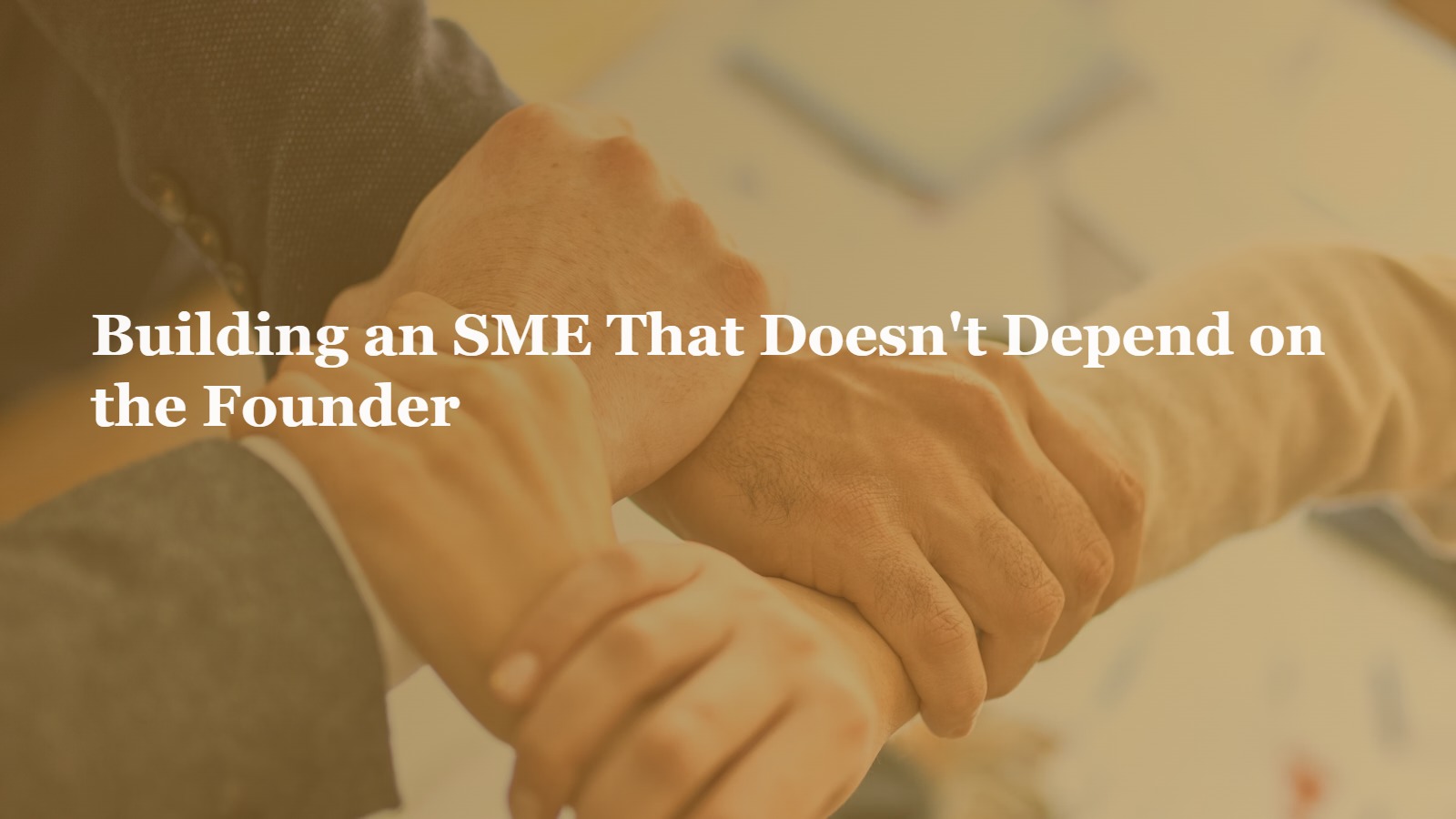 Team stacking hands together representing delegation and shared ownership in a growing SME