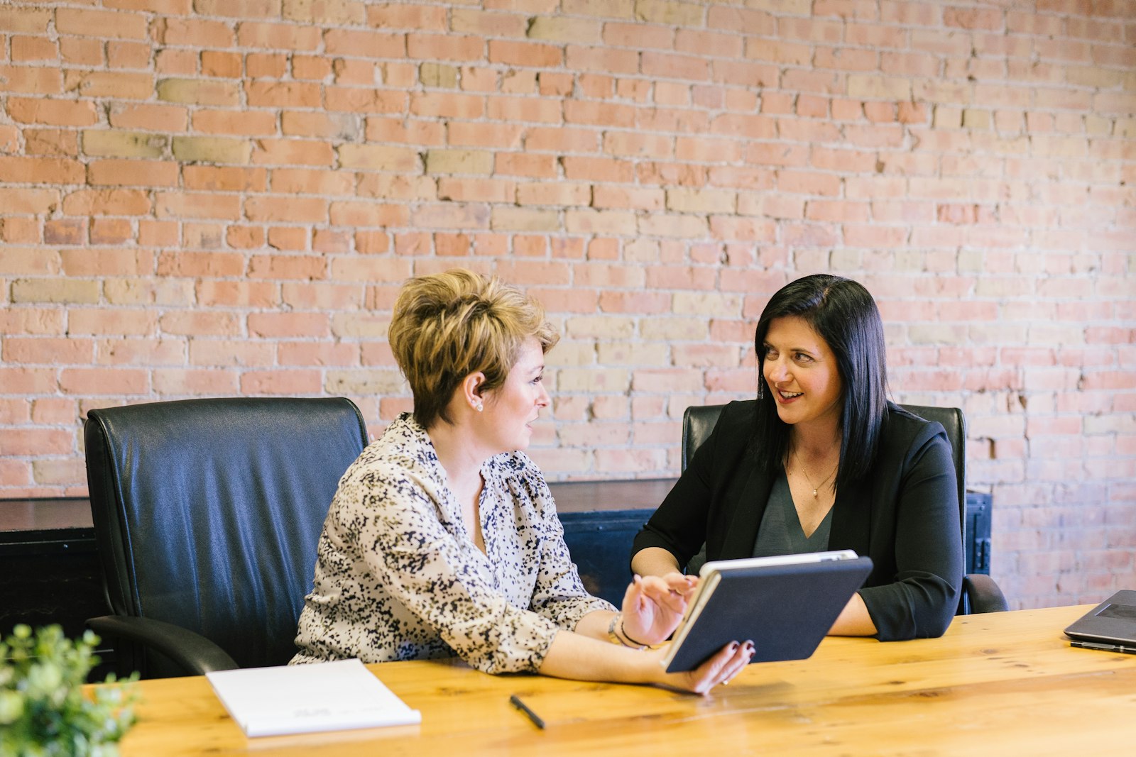 Two colleagues in a candid one-on-one conversation, representing the quiet leadership skills like trust and self-awareness that build real influence