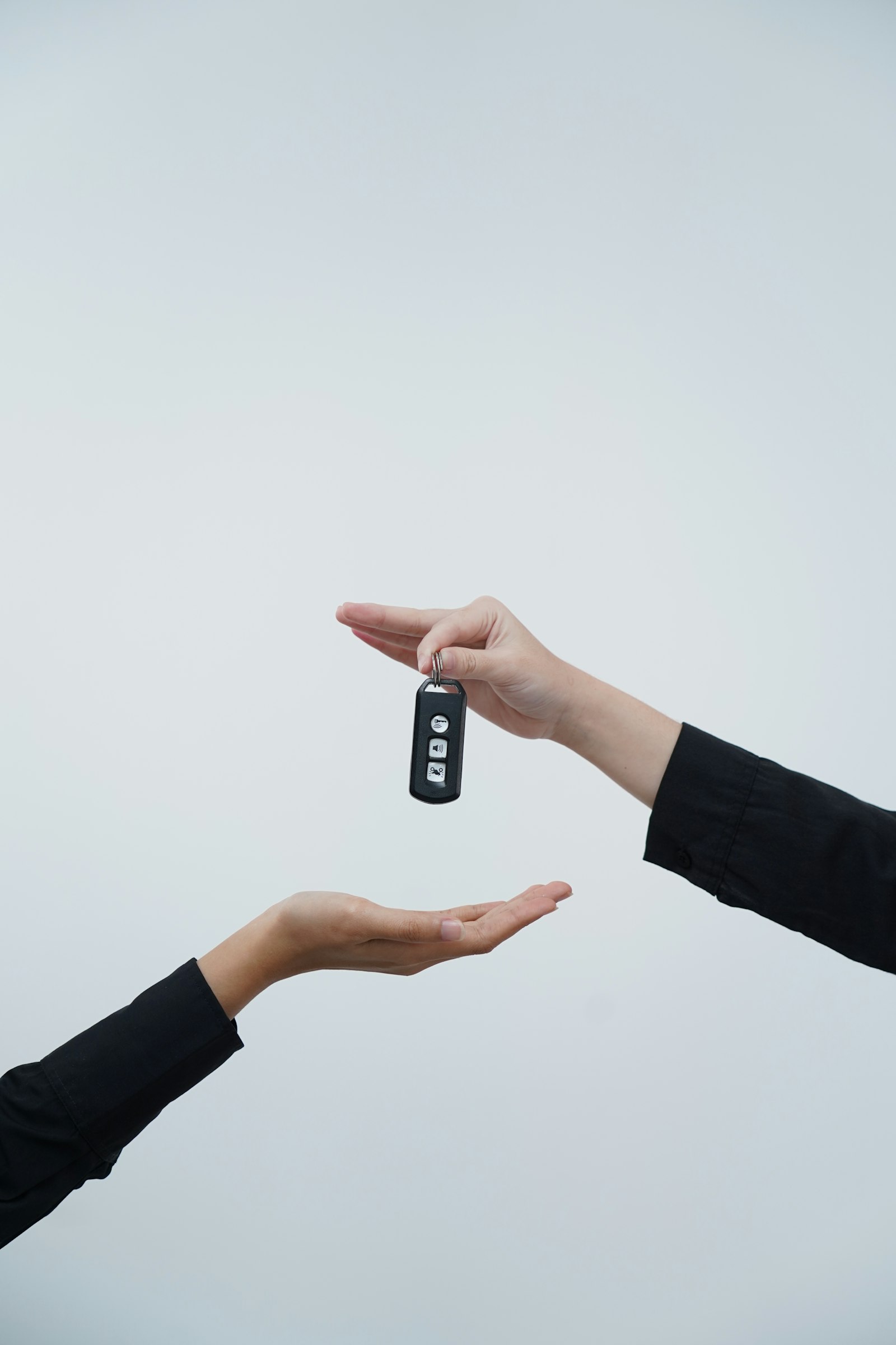 Hands exchanging a set of keys, representing a business owner handing over control as part of succession planning